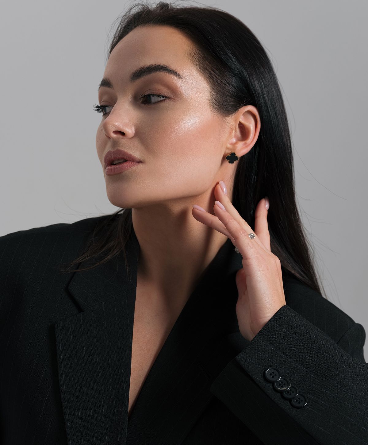 Model showcasing elegance in black attire and jewelry.