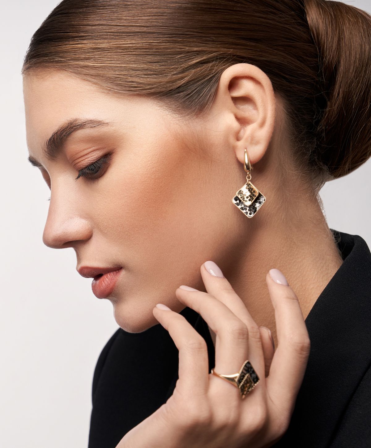 Model showcasing elegant earrings and ring.